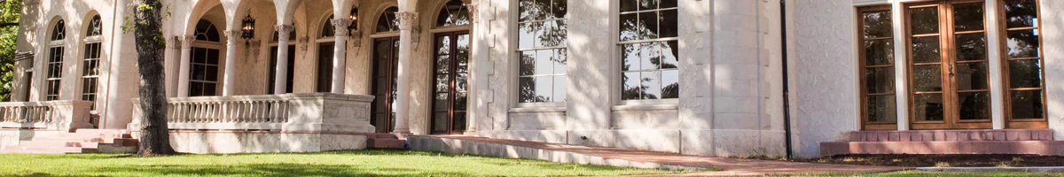 Commodore Perry State ranch in Texas with large windows in a white building surrounded by trees and fields