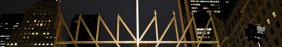 The world's largest Menorah in golden color and on a background with buildings at nightfall